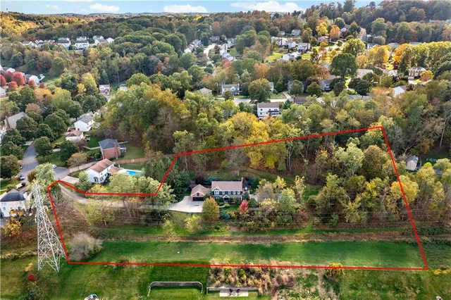 an aerial view of a houses with a yard and lake view