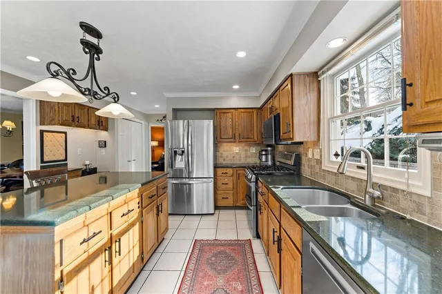 a kitchen with stainless steel appliances granite countertop a sink a stove and a wooden floors