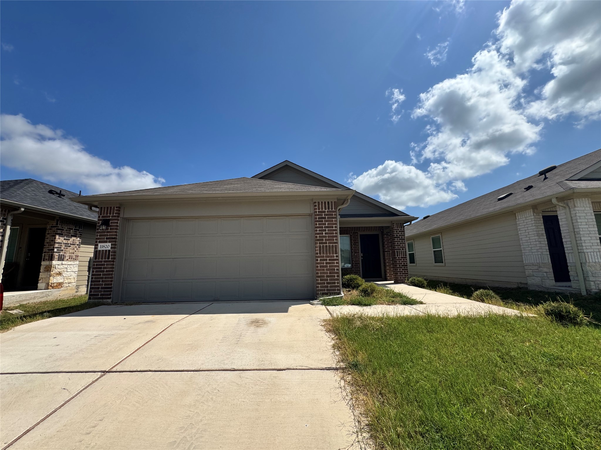 11820 Rush Lane Elgin, TX 78621 - Photo 1 of 31 Concrete driveway leads to this brick and siding home with an attached garage.