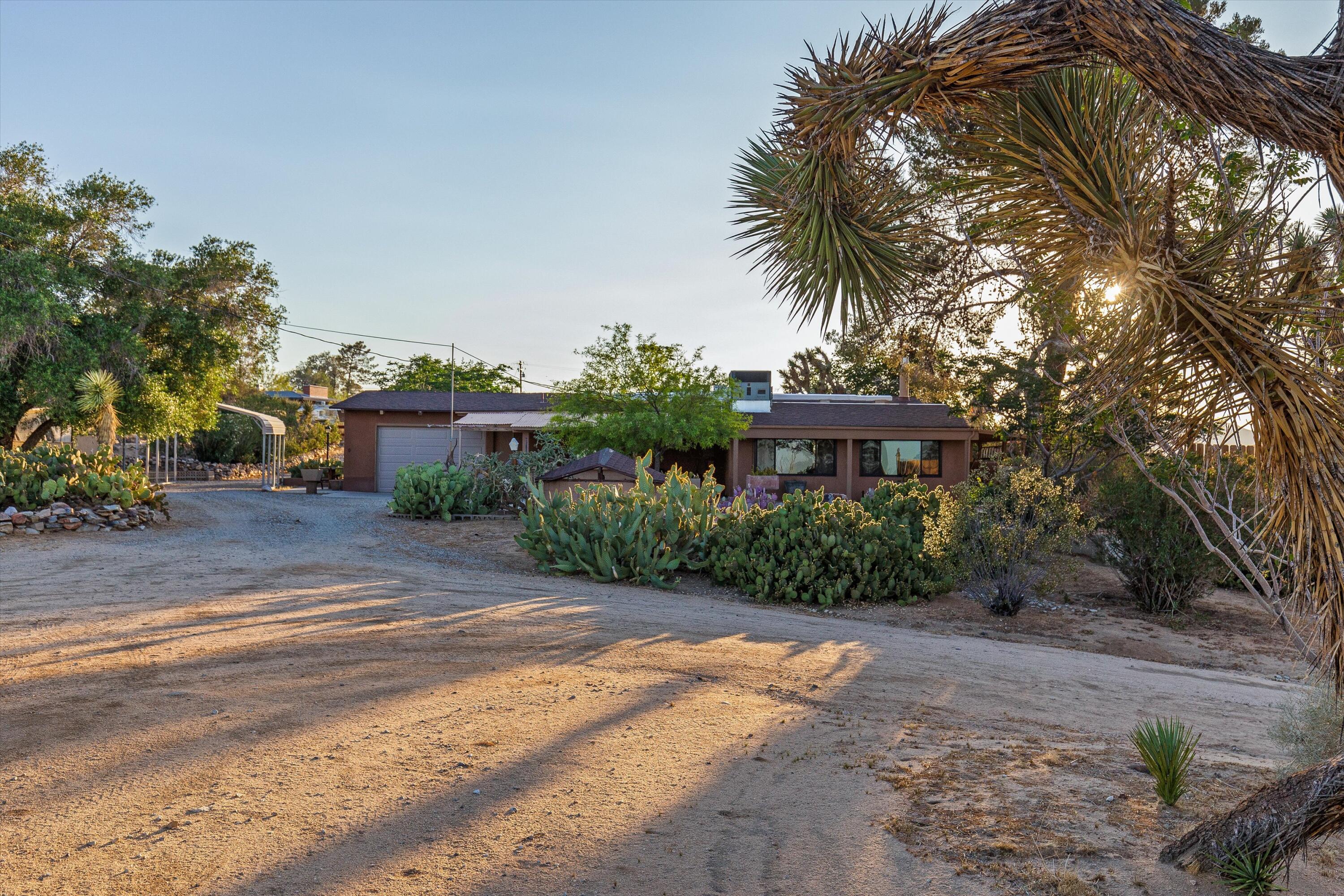 6785 Saddleback Road Joshua Tree, CA 92252 - Photo 40 of 50 a front view of a house with a yard and garage