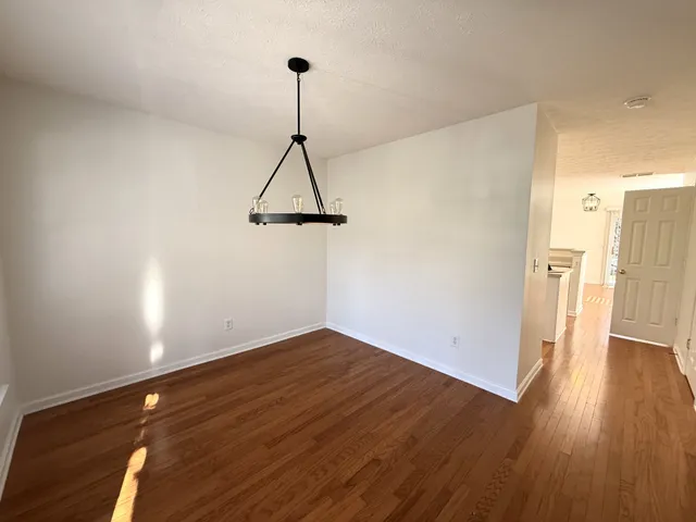 a view of empty room with wooden floor and window