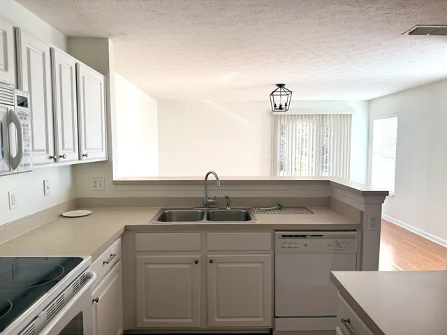 a kitchen with cabinets appliances and a window
