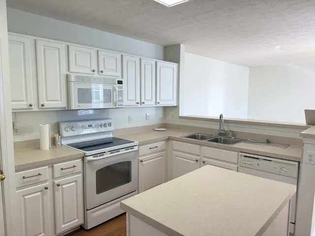 a kitchen with cabinets appliances a sink and a counter top space