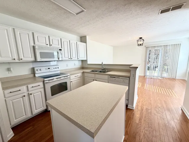 a kitchen with cabinets appliances and wooden floor