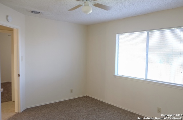 12250 Ridge Crown Street San Antonio, TX 78247 - Photo 10 of 15 an empty room with a window and a fan