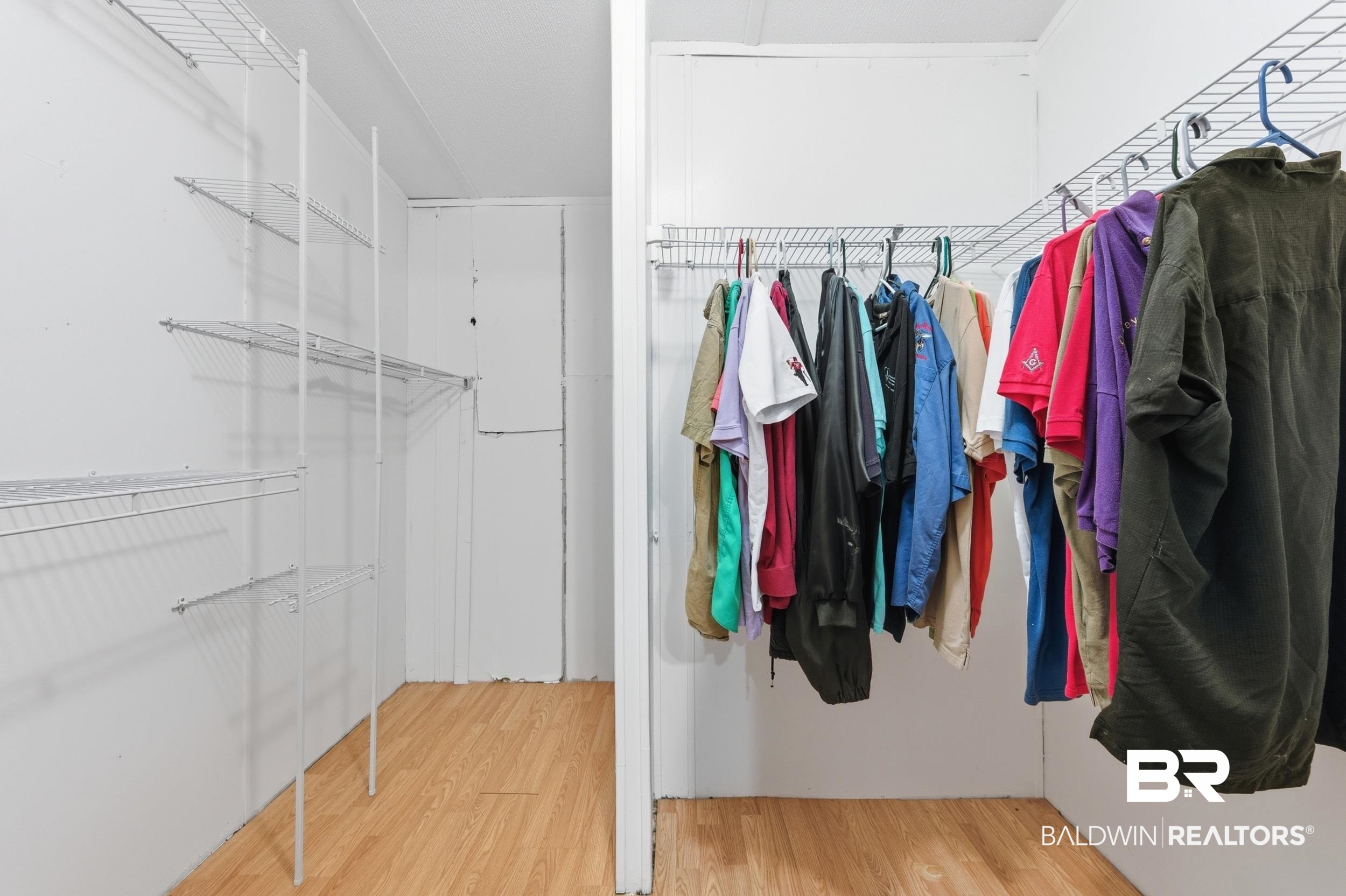 926 Tumbling Lane Atmore, AL 36502 - Photo 34 of 56 Walk-in closet featuring wire shelving, hanging rods, and wood-finish flooring