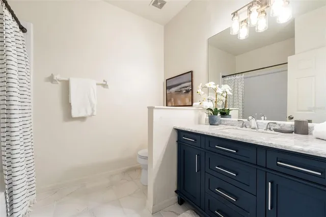 a bathroom with a granite countertop sink a mirror and shower