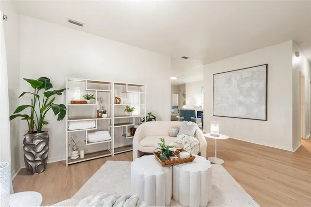 a living room with furniture flowerpot and a chandelier