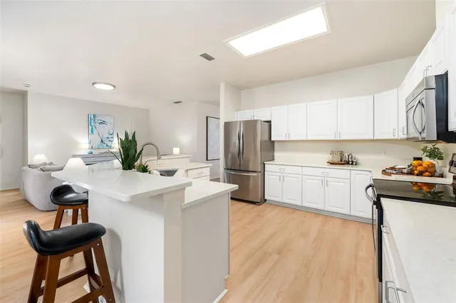 a kitchen with white cabinets and appliances