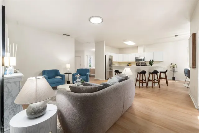 a living room with furniture kitchen and a table