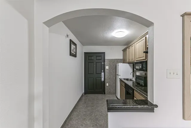 a hallway with a stove and a refrigerator