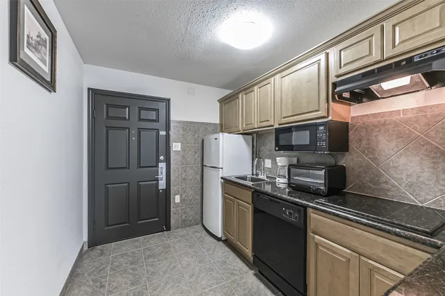 a kitchen with stainless steel appliances granite countertop a refrigerator and a sink