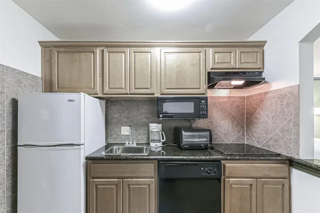 a kitchen with appliances a sink and cabinets