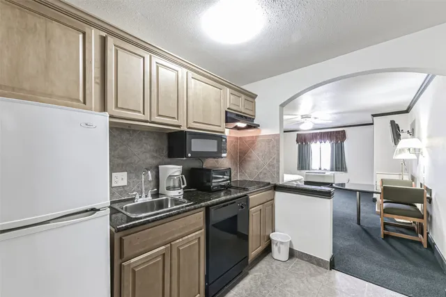 a kitchen with granite countertop a sink stainless steel appliances and cabinets