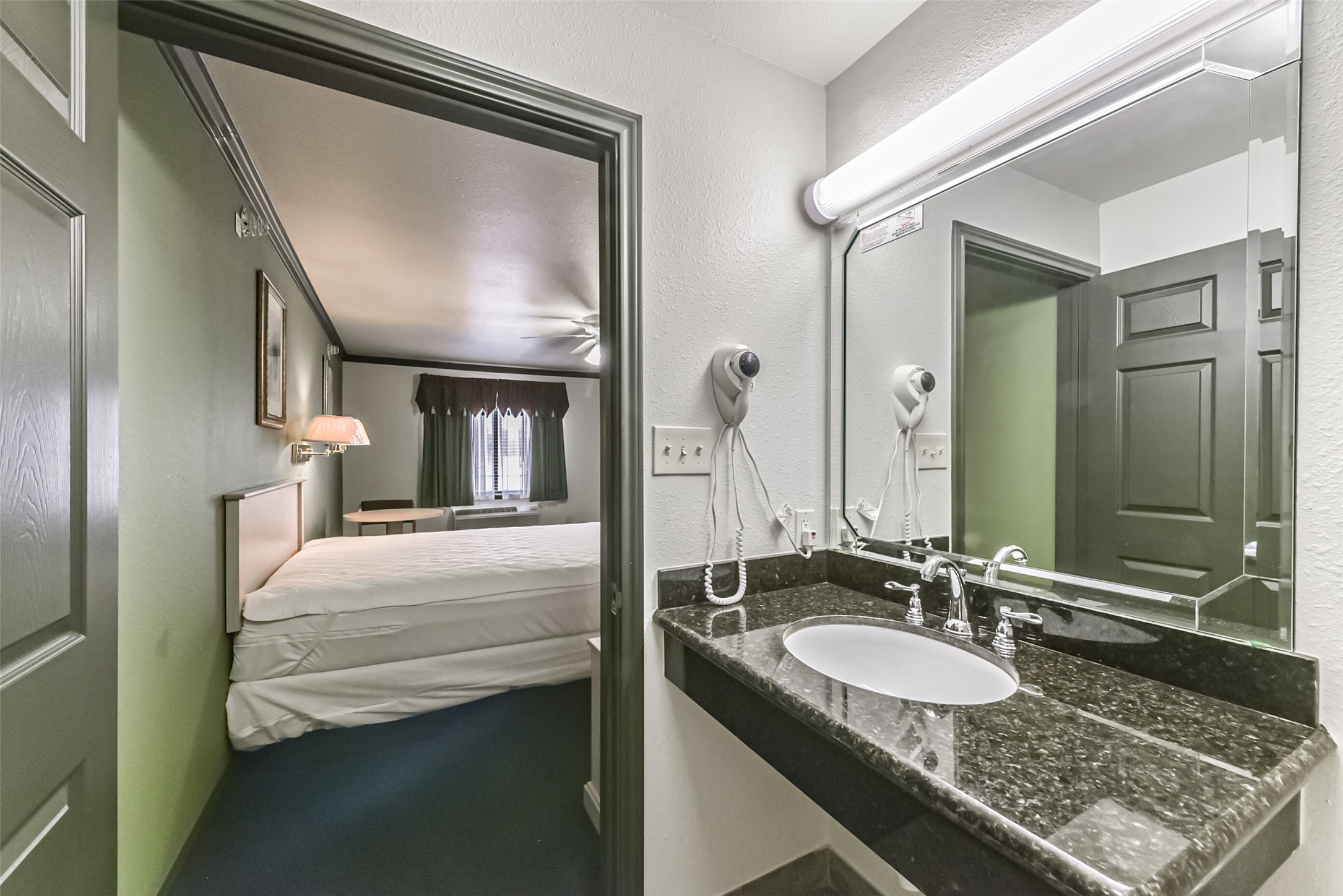 1025 Swanson Street, Unit 313 Houston, TX 77030 - Photo 21 of 25 a en suite bathroom with a granite countertop sink and a mirror