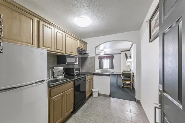 a kitchen with stainless steel appliances granite countertop a refrigerator a stove a sink and a microwave