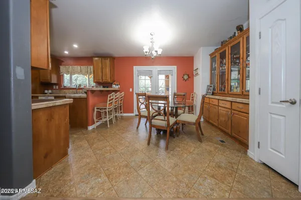a kitchen with granite countertop cabinets a dining table and chairs a refrigerator with wooden floor