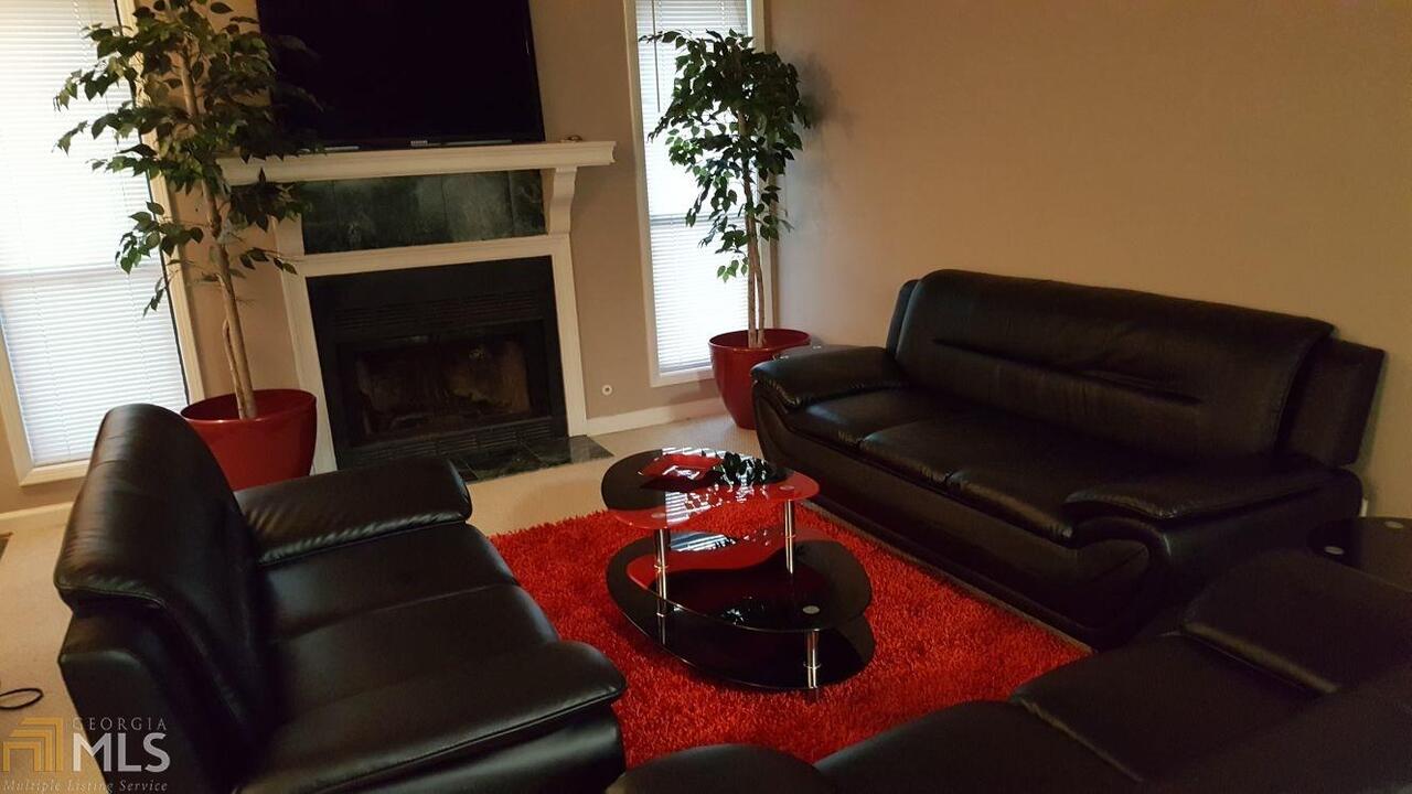 a living room with furniture fireplace and potted plants
