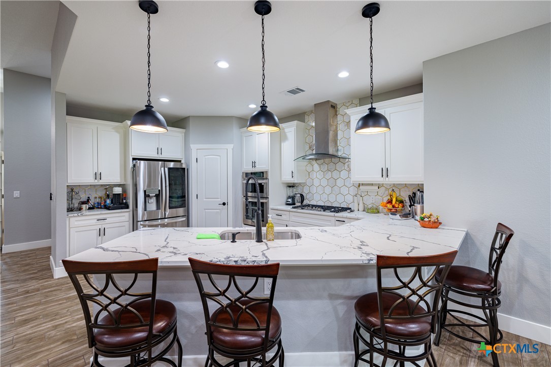 200 Wood Cove Georgetown, TX 78633 - Photo 15 of 22 a kitchen with stainless steel appliances kitchen island a table and chairs