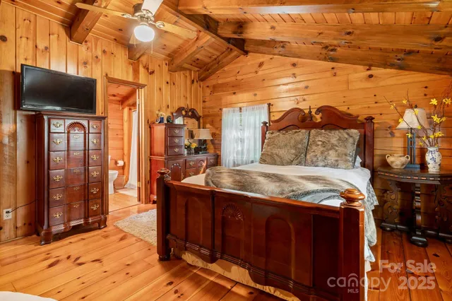 a bedroom with a bed and a flat tv screen next to a window