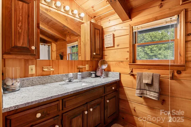 a bathroom with a granite countertop sink and a window