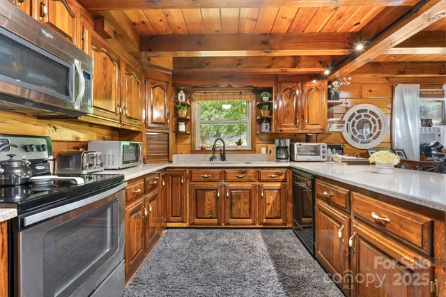 a kitchen with stainless steel appliances granite countertop a sink stove and cabinets