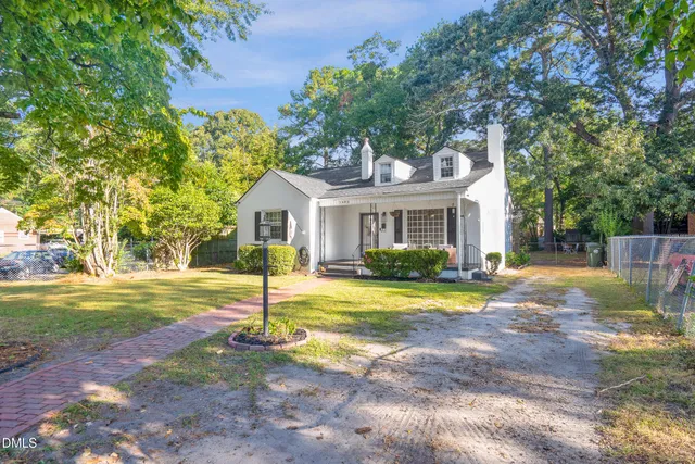 a view of a house with backyard and a tree