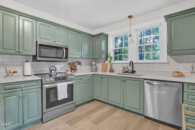 a kitchen with stainless steel appliances granite countertop a sink stove and cabinets