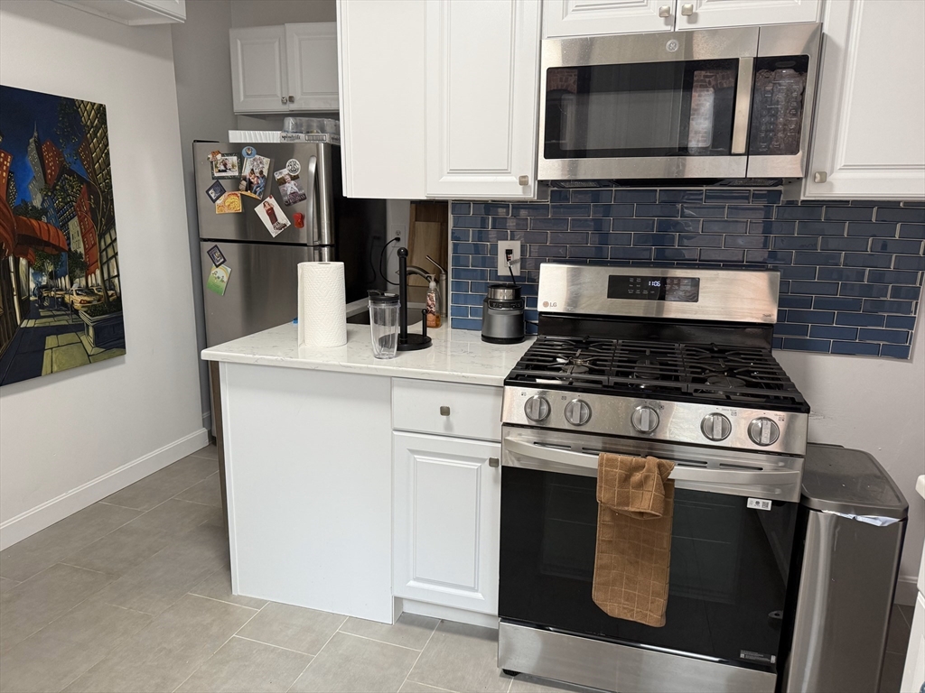36 Orkney Road, Unit 3 Boston, MA 02135 - Photo 3 of 11 a kitchen with stainless steel appliances granite countertop a stove and a microwave