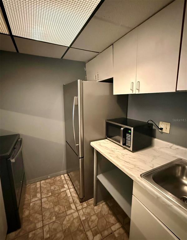 1019 West Sumner Street Kissimmee, FL 34741 - Photo 10 of 12 a kitchen with a refrigerator and a sink