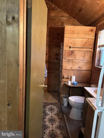 a bathroom with a granite countertop toilet sink and mirror