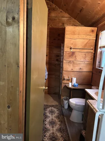 a bathroom with a granite countertop toilet sink and mirror
