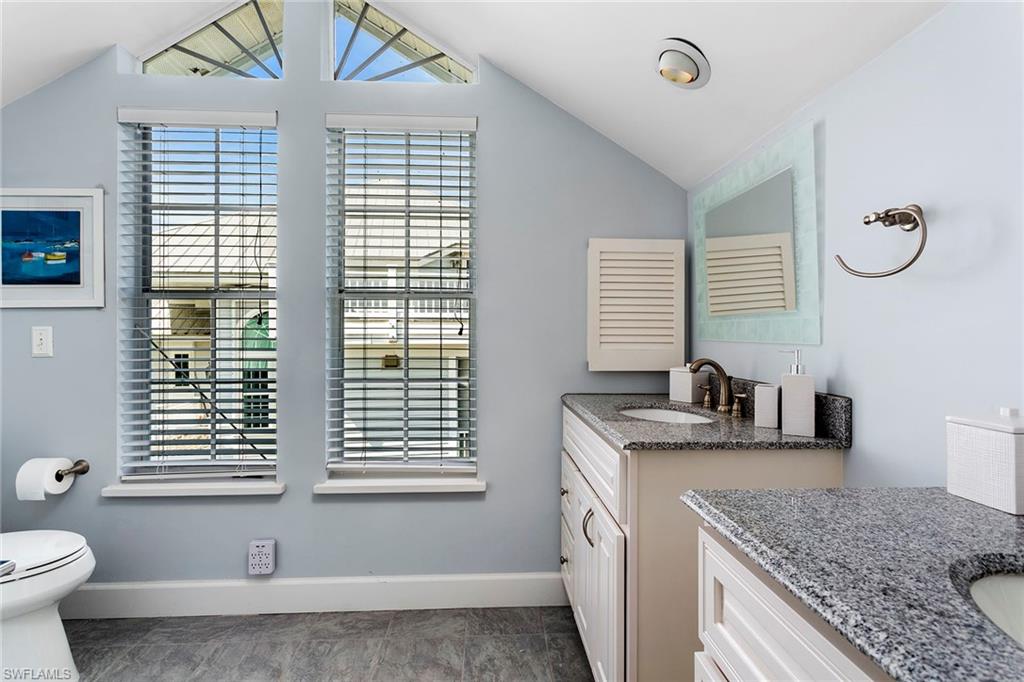 143 Useppa Island Bokeelia, FL 33922 - Photo 14 of 22 Bathroom featuring two vanities and vaulted ceiling