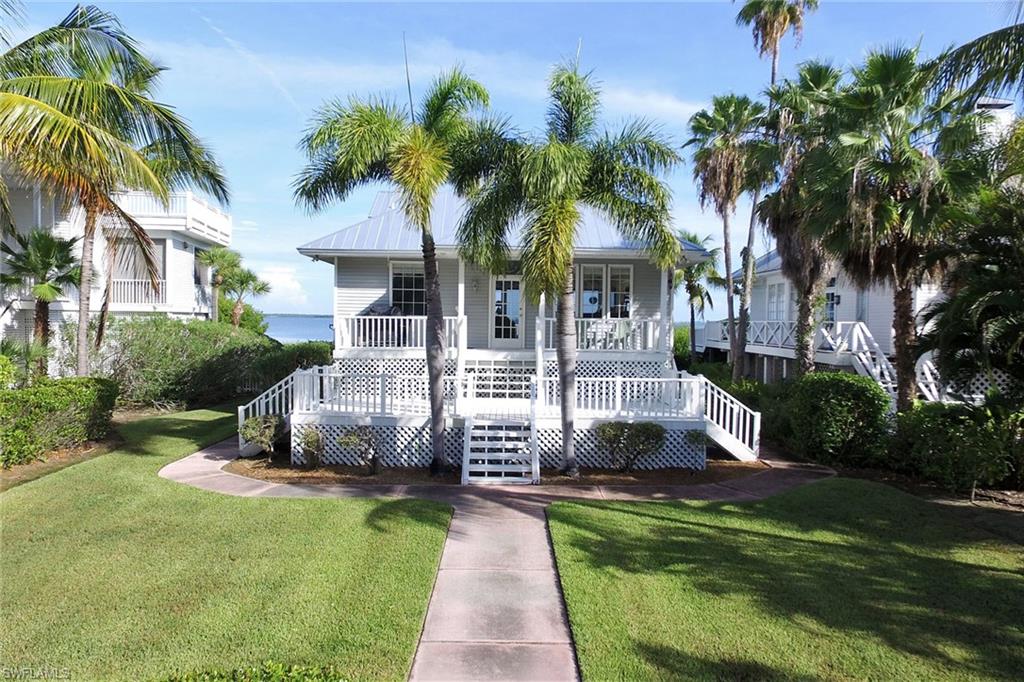 143 Useppa Island Bokeelia, FL 33922 - Photo 22 of 22 View of front of house featuring stairway, a front yard, and a metal roof