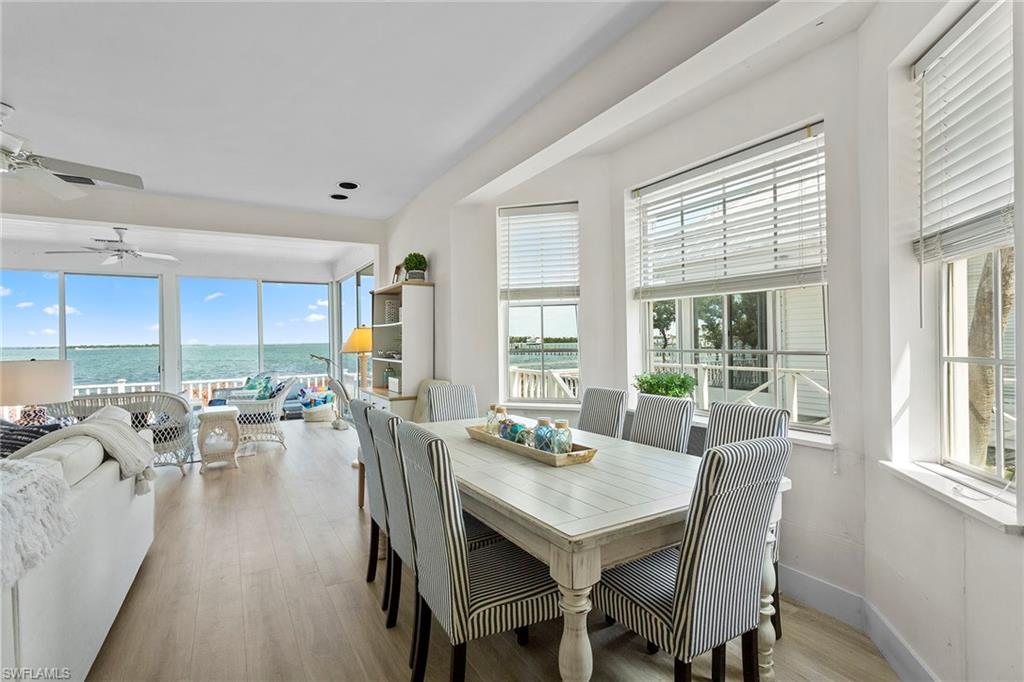 143 Useppa Island Bokeelia, FL 33922 - Photo 5 of 22 Dining area with a water view, light wood finished floors, and ceiling fan