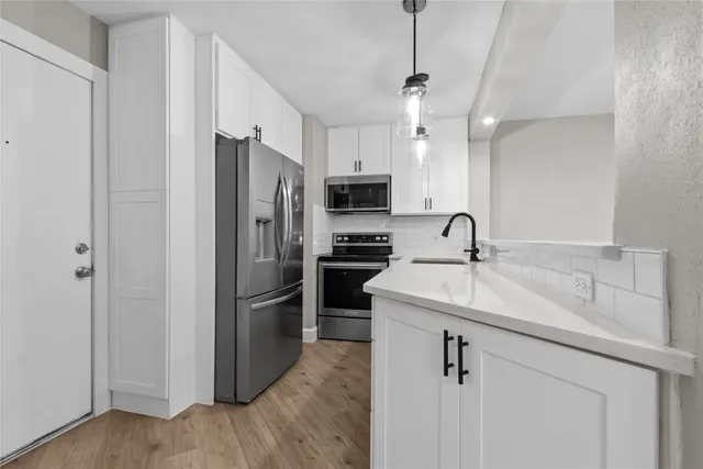a kitchen with kitchen island a sink stainless steel appliances and cabinets