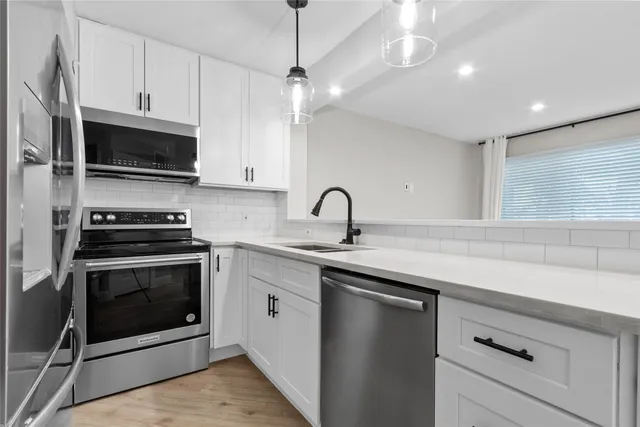 a kitchen with stainless steel appliances a stove a sink and a microwave