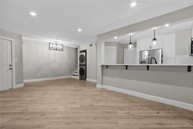a view of a kitchen with wooden floor and cabinets