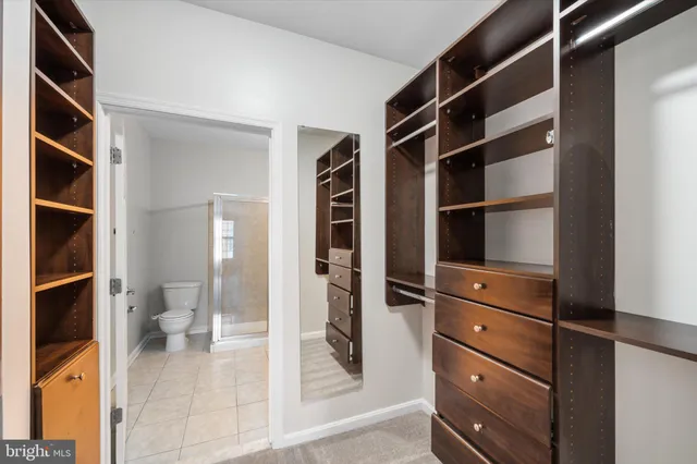a view of walk in closet with clothes and shoes
