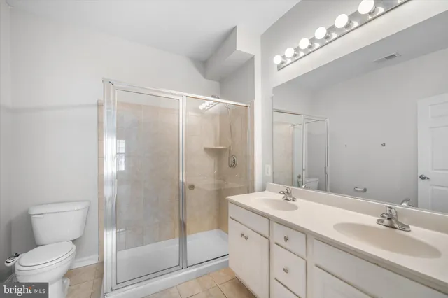 a bathroom with a double vanity sink mirror and toilet