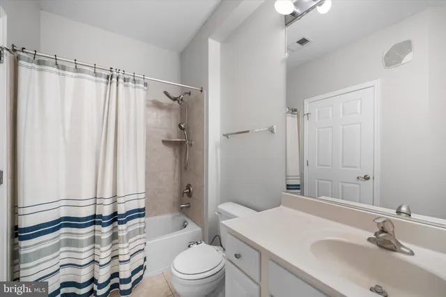 a bathroom with a sink a toilet a mirror and shower