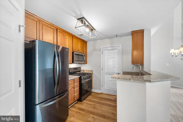 a kitchen with stainless steel appliances granite countertop a refrigerator a stove a sink and dishwasher
