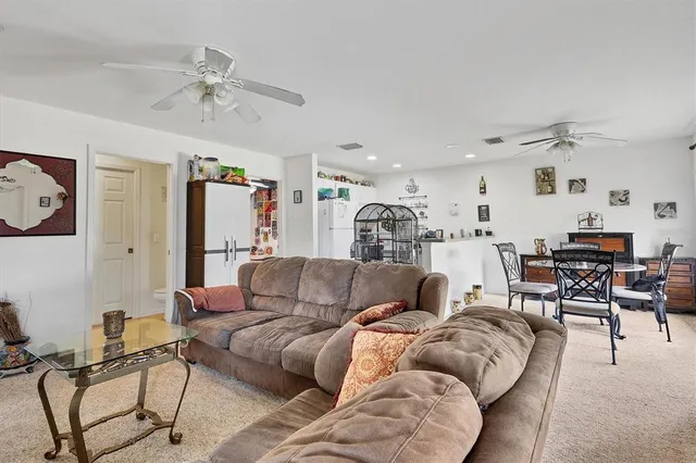 a living room with furniture and a view of kitchen