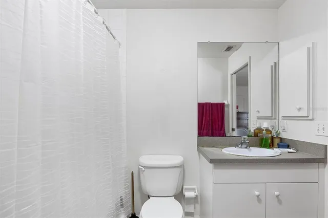 a bathroom with a toilet a sink and mirror