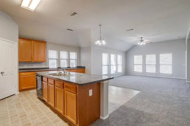a kitchen with stainless steel appliances granite countertop a sink and a stove