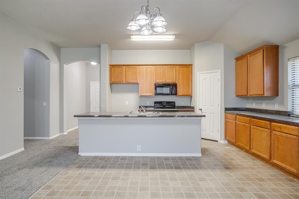 928 Remington Ranch Road Mansfield, TX 76063 - Photo 7 of 20 a kitchen with stainless steel appliances granite countertop a stove a sink and a refrigerator