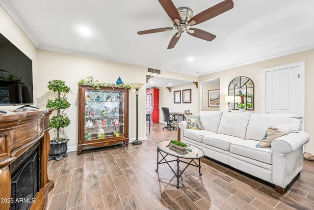 a living room with furniture and a flat screen tv with kitchen view