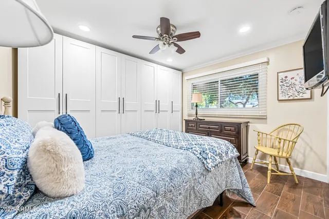 a bed sitting in a room next to a window and a chandelier