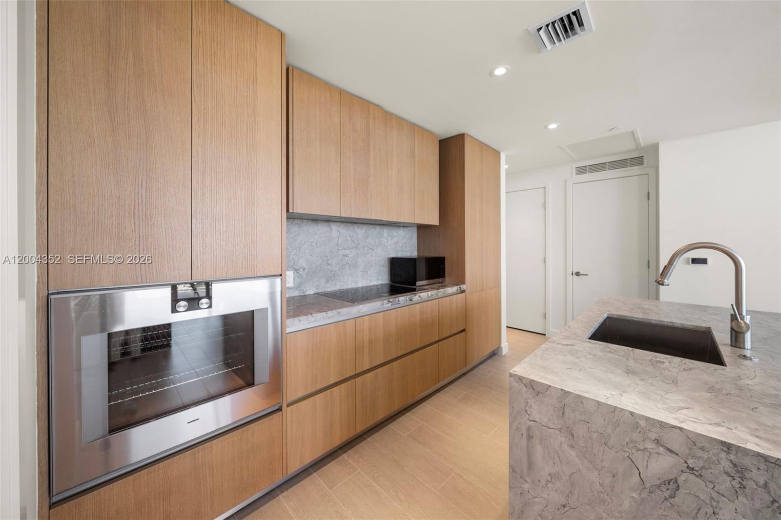 500 Alton Road, Unit 1707 Miami Beach, FL 33139 - Photo 30 of 52 a kitchen with granite countertop white cabinets and stainless steel appliances
