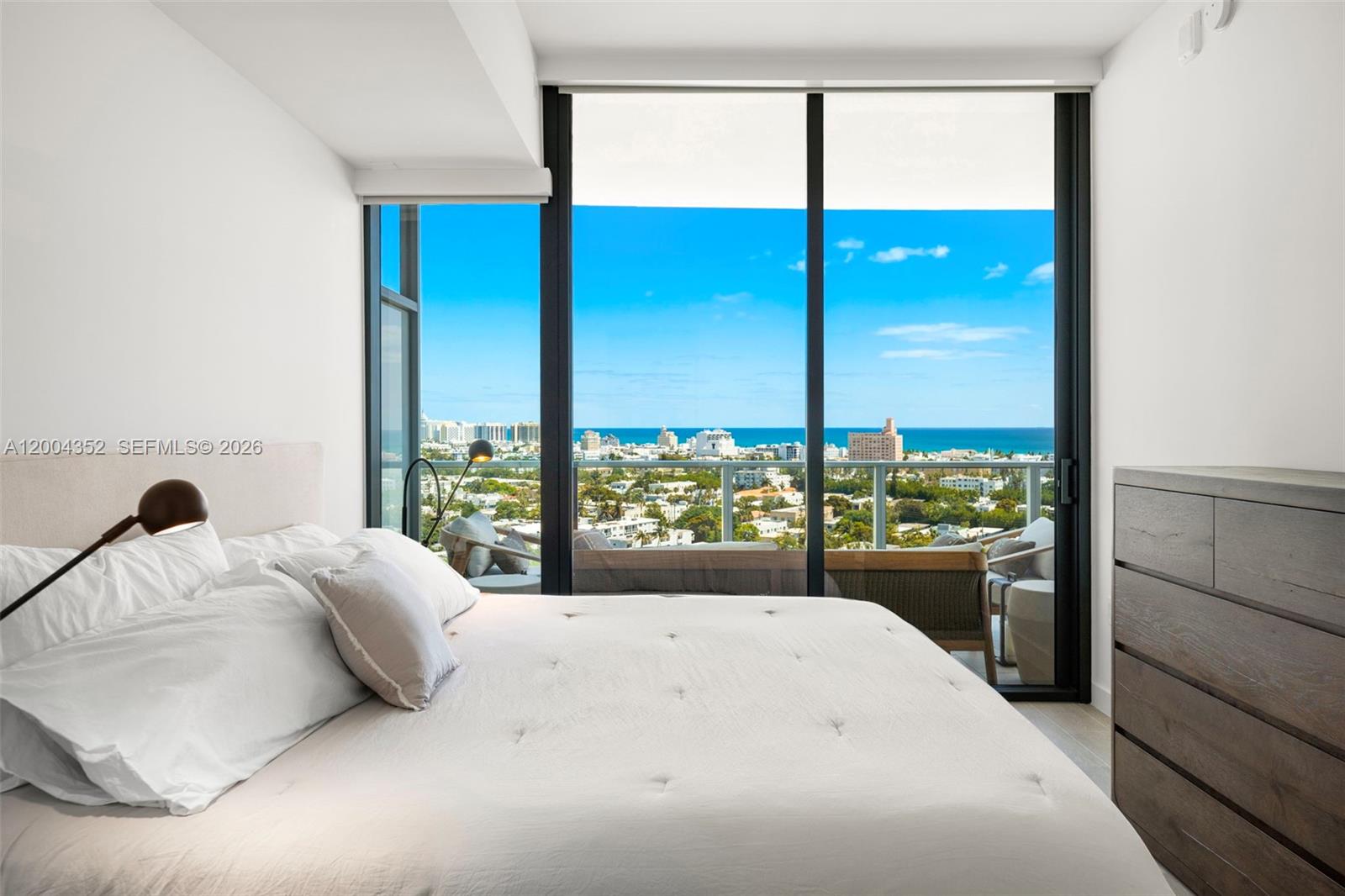 500 Alton Road, Unit 1707 Miami Beach, FL 33139 - Photo 32 of 52 a bedroom with a large window and a bed